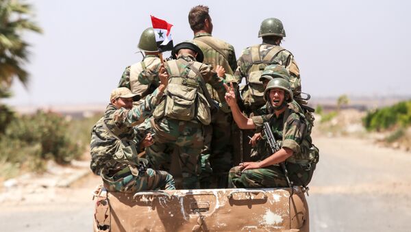 A Syrian government soldier flashes the victory gesture while riding in the back of a pickup truck with comrades at the Nassib border crossing with Jordan in the southern province of Daraa on July 7, 2018 - Sputnik International