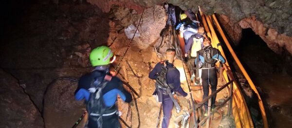 In this undated photo released by Royal Thai Navy on Saturday, July 7, 2018, Thai rescue team members walk inside a cave where 12 boys and their soccer coach have been trapped since June 23, in Mae Sai, Chiang Rai province, northern Thailand - Sputnik International