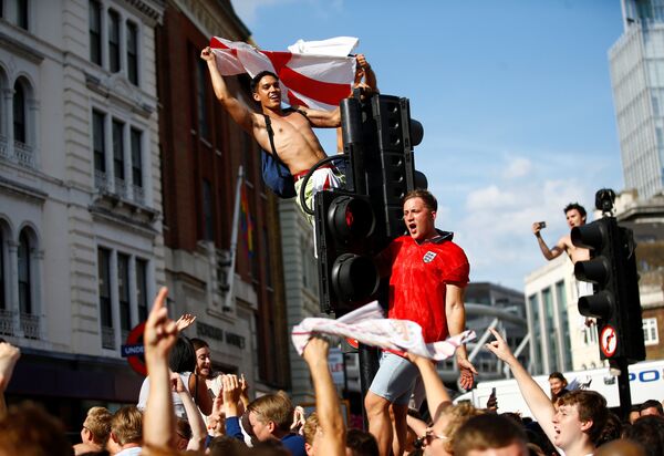 Soccer Football - World Cup - England fans watch Sweden vs England - London, Britain - July 7, 2018 England fans celebrate by climbing traffic lights after the match - Sputnik International