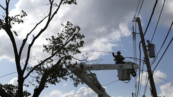 A National Grid crew member works to restore power on lines in Revere, Mass. Monday, July 28, 2014, after a tornado touched down - Sputnik International