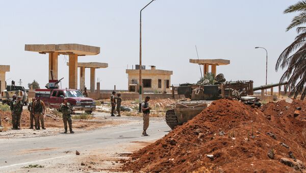 Syrian government soldiers stand by a tank and armed pickup trucks at the Nassib border crossing with Jordan in the southern province of Daraa on July 7, 2018 - Sputnik International