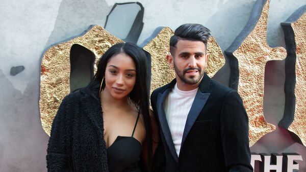 Leicester City footballer Riyad Mahrez (R) and his wife Rita pose for a photograph upon arrival at the European Premiere of King Arthur: legend of the Sword in London on May 10, 2017 - Sputnik International