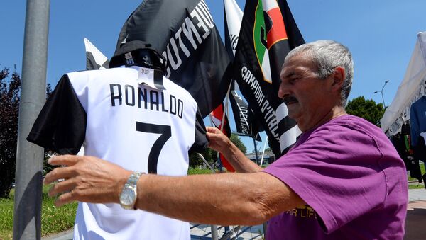 A vendor adjusts a Juventus' jerseys with the name of Cristiano Ronaldo exhibited in his shop in Turin, Italy July 7, 2018 - Sputnik International