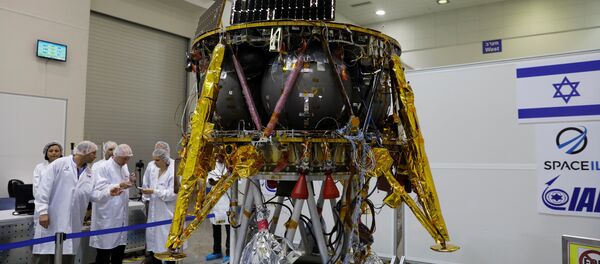 Israeli scientists stand next to an unmanned spacecraft which an Israeli team plans to launch into space at the end of the year and to land it on the Moon next year, in Yahud, Israel, July 10, 2018 - Sputnik International