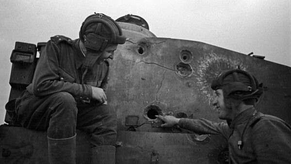 Two Soviet tankmen sitting on a disabled Tiger tank. The Kursk Bulge - Sputnik International