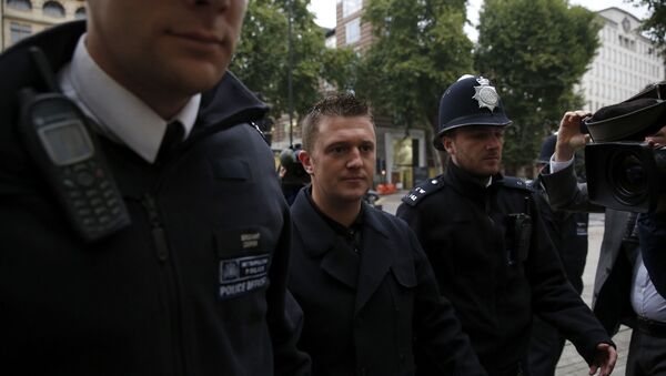 Tommy Robinson the former leader of the far-right EDL English Defence League group is flanked by police officers as he arrives for an appearance at Westminster Magistrates Court in London, Wednesday, Oct. 16, 2013 - Sputnik International