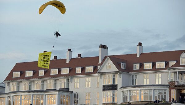 In this Friday, July 13, 2018 photo, a Greenpeace protester flying a microlight passes over US President's Donald Trump's resort in Turnberry, South Ayrshire, Scotland with a banner reading Trump: Well Below Par, shortly after the US President arrived at the hotel. Scottish police said the protester breached a no-fly zone over Turnberry hotel and committed a criminal offence. - Sputnik International