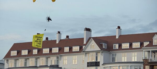 In this Friday, July 13, 2018 photo, a Greenpeace protester flying a microlight passes over US President's Donald Trump's resort in Turnberry, South Ayrshire, Scotland with a banner reading Trump: Well Below Par, shortly after the US President arrived at the hotel. Scottish police said the protester breached a no-fly zone over Turnberry hotel and committed a criminal offence. - Sputnik International