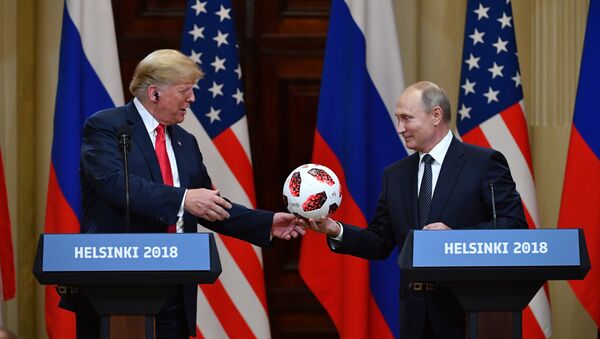 Russia's President Vladimir Putin (R) offers a ball of the 2018 football World Cup to US President Donald Trump during a joint press conference after a meeting at the Presidential Palace in Helsinki, on July 16, 2018 - Sputnik International