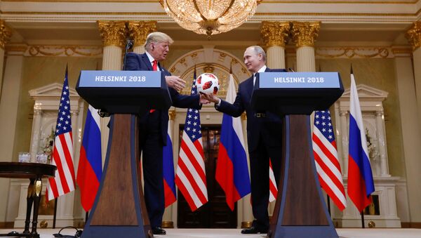 U.S. President Donald Trump receives a football from Russia's President Vladimir Putin during their joint news conference after a meeting in Helsinki, Finland, July 16, 2018 - Sputnik International