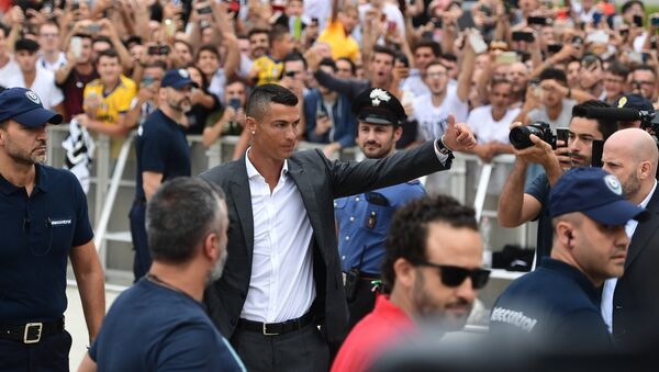 Cristiano Ronaldo waves to suppoters as he arrives on July 16, 2018 at the Juventus medical centre at the Alliance stadium in Turin - Sputnik International