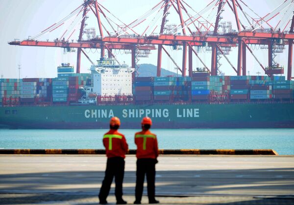 Chinese workers stand on a pier before a cargo ship at a port in Qingdao, east China's Shandong province on April 13, 2017 - Sputnik International