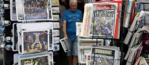 A man walks past racks which display copies of French daily newspapers with front pages about France's win in the World Cup, in Nice, France, July 16, 2018 - Sputnik International