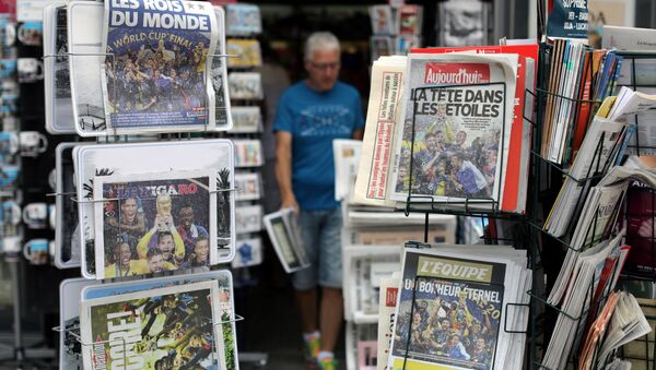 A man walks past racks which display copies of French daily newspapers with front pages about France's win in the World Cup, in Nice, France, July 16, 2018 - Sputnik International
