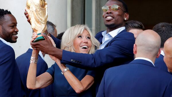 Brigitte Macron, the wife of French President Emmanuel Macron (not pictured), and player Paul Pogba hold the trophy before a reception to honour the France soccer team after their victory in the 2018 Russia Soccer World Cup, at the Elysee Palace in Paris, France, July 16, 2018 - Sputnik International