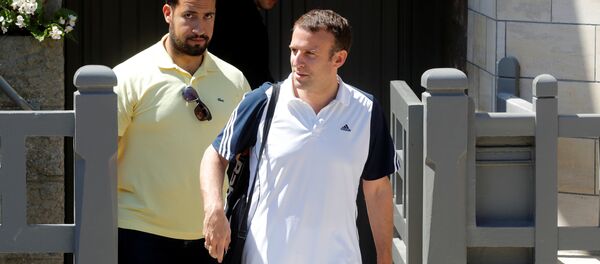 French President Emmanuel Macron, flanked by Alexandre Benalla, French presidential aide, carries a racquet as he leaves his home to play tennis in Le Touquet, France, June 17, 2017. Picture taken June 17, 2017 - Sputnik International