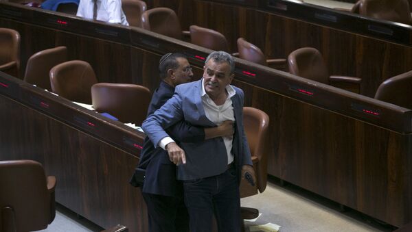 A Knesset usher removes Jamal Zahalka, an Israeli Arab member of the Knesset representing the Balad party, who was protesting the passage of a contentious bill, during a Knesset session in Jerusalem, Thursday, July 19, 2018. Israel's parliament approved a controversial piece of legislation early Thursday that defines the country as the nation-state of the Jewish people. Opponents and rights groups have criticized the legislation, warning that it will sideline minorities such as the country's Arabs - Sputnik International