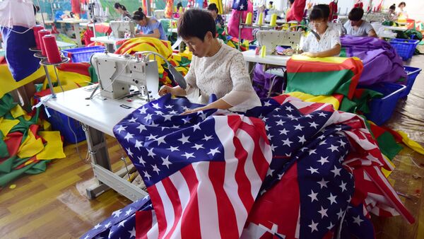 This photo taken on July 13, 2018 shows Chinese employees sewing US flags at a factory in Fuyang in China's eastern Anhui province. As the Sino-US trade war rages, a factory set amid corn and mulberry fields in central China stitches together US and Trump 2020 flags -- and business is good - Sputnik International