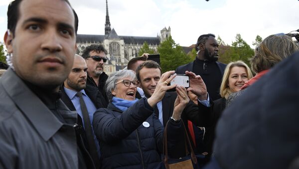 French presidential election candidate for the En Marche ! movement Emmanuel Macron (C-R) poses for a 'selfie' with a supporter outside the Amiens Cathedral on April 26, 2017, as Macron's bodyguard nicknamed Makao (2ndR) and bodyguard Alexandre Benalla (L) stand guard around him - Sputnik International