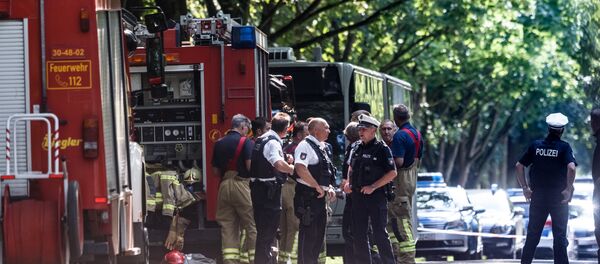 Policemen stand near a public service bus in Kuecknitz near Luebeck northern Germany, after several people were injured in the bus in an assault by a man wielding a knife on July 20, 2018 - Sputnik International
