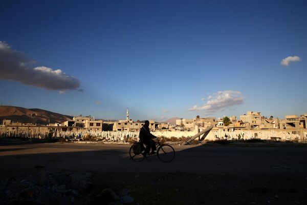 A man rides a bicycle near a cemetery in the rebel-held besieged town of Douma, eastern Ghouta in Damascus, Syria November 1, 2016. A man rides a bicycle near a cemetery in the rebel-held besieged town of Douma, eastern Ghouta in Damascus, Syria November 1, 2016. - Sputnik International