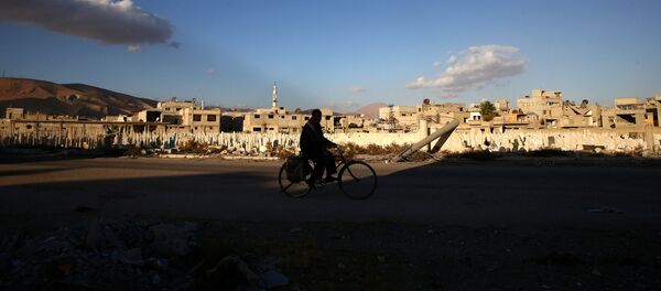 A man rides a bicycle near a cemetery in the rebel-held besieged town of Douma, eastern Ghouta in Damascus, Syria November 1, 2016. A man rides a bicycle near a cemetery in the rebel-held besieged town of Douma, eastern Ghouta in Damascus, Syria November 1, 2016. - Sputnik International