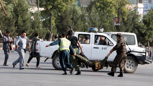 Afghan policemen carry a wounded man at the site of a blast in Kabul, Afghanistan, July 22, 2018 - Sputnik International