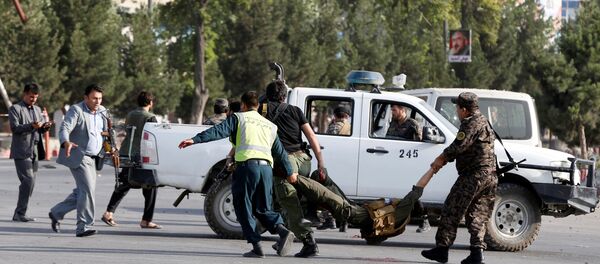 Afghan policemen carry a wounded man at the site of a blast in Kabul, Afghanistan, July 22, 2018 - Sputnik International