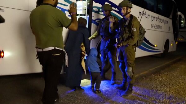 People walk past Israeli soldiers as they board a bus during the Syria Civil Defence, also known as the White Helmets, extraction from the Golan Heights, Israel in this still image taken from video, provided by the Israeli Army July 22, 2018 People walk past Israeli soldiers as they board a bus during the Syria Civil Defence, also known as the White Helmets, extraction from the Golan Heights, Israel in this still image taken from video, provided by the Israeli Army July 22, 2018 - Sputnik International