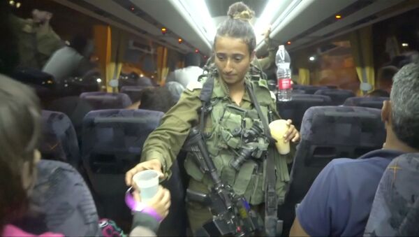 An Israeli solider hands out water on a bus, during the Syria Civil Defence, also known as the White Helmets, extraction from the Golan Heights, Israel in this still image taken from video, provided by the Israeli Army July 22, 2018 - Sputnik International