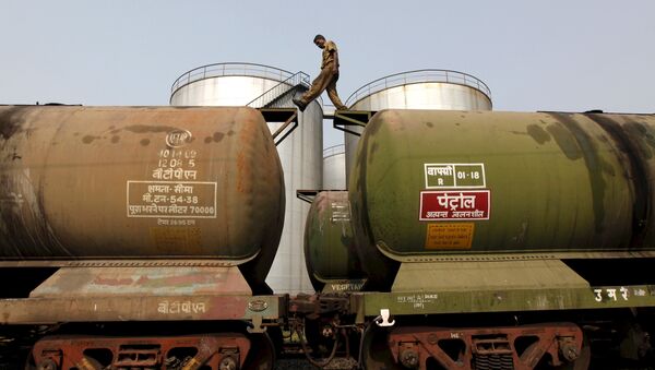 A worker walks atop a tanker wagon to check the freight level at an oil terminal on the outskirts of Kolkata, India November 27, 2013 - Sputnik International