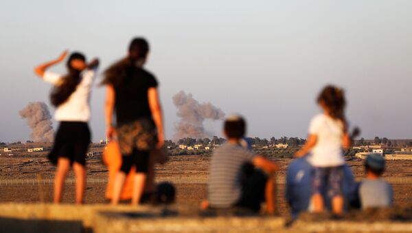 Israeli kids look over the Israeli Syrian border as smoke can be seen following an explosion at its Syrian side it is seen from the Israeli-occupied Golan Heights, Israel July 23, 2018 - Sputnik International