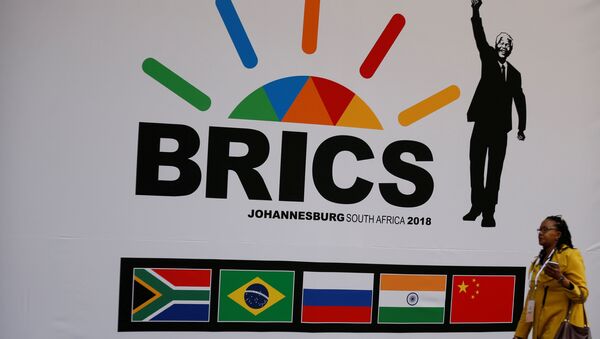 A delegate walks past a BRICS logo ahead of the 10th BRICS Summit, in Sandton, South Africa, July 24, 2018 - Sputnik International