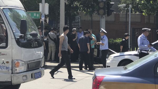 Officials and security personnel stand near the site of a reported blast outside the U.S. Embassy in Beijing, Thursday, July 26, 2018. - Sputnik International