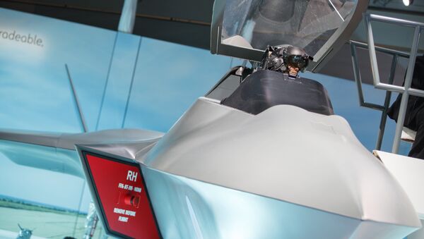 A visitor sits in the model of a new fighter jet, a part of Team Tempest, during the Farnborough Airshow, south west of London, on July 16, 2018 - Sputnik International