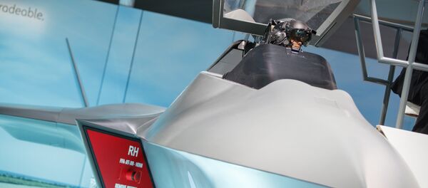 A visitor sits in the model of a new fighter jet, a part of Team Tempest, during the Farnborough Airshow, south west of London, on July 16, 2018 - Sputnik International