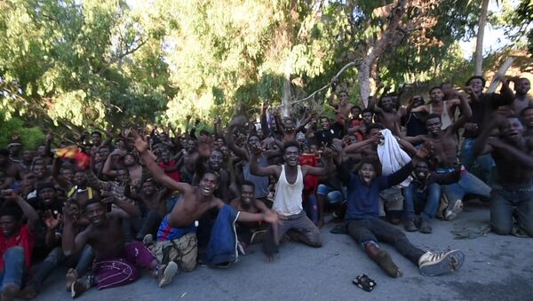 African migrants react in this still image from video after crossing the border from Morocco to Spain's North African enclave of Ceuta, Spain, July 26, 2018 - Sputnik International