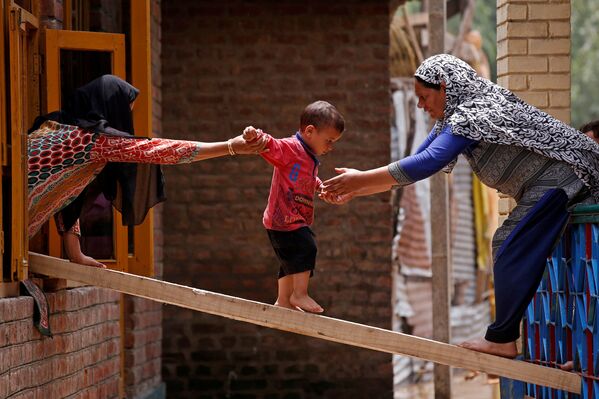 Women help child escape house after flash floods in Kashmir - Sputnik International
