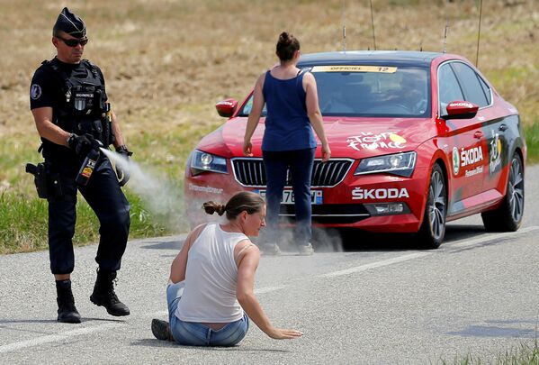 Police officer pepper sprays protester during Tour de France. - Sputnik International