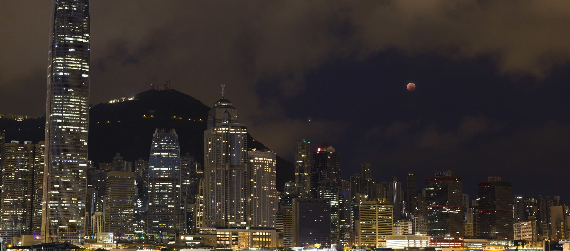 A full moon rises over the Victoria Harbour during a complete lunar eclipse, in Hong Kong, Saturday, July 28, 2018. Skywatchers around much of the world are looking forward to a complete lunar eclipse that will be the longest this century. - Sputnik International, 1920, 07.10.2018
