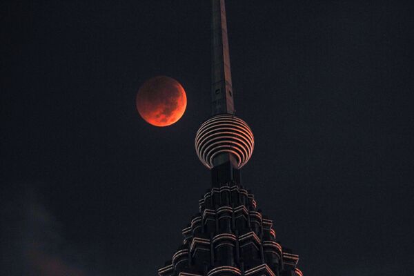 A full moon sets over Petronas Twin Tower during a complete lunar eclipse in Kuala Lumpur, Malaysia, Saturday, July 28, 2018. Skywatchers around much of the world are looking forward to a complete lunar eclipse that will be the longest this century. A full moon sets over Petronas Twin Tower during a complete lunar eclipse in Kuala Lumpur, Malaysia, Saturday, July 28, 2018. Skywatchers around much of the world are looking forward to a complete lunar eclipse that will be the longest this century. - Sputnik International