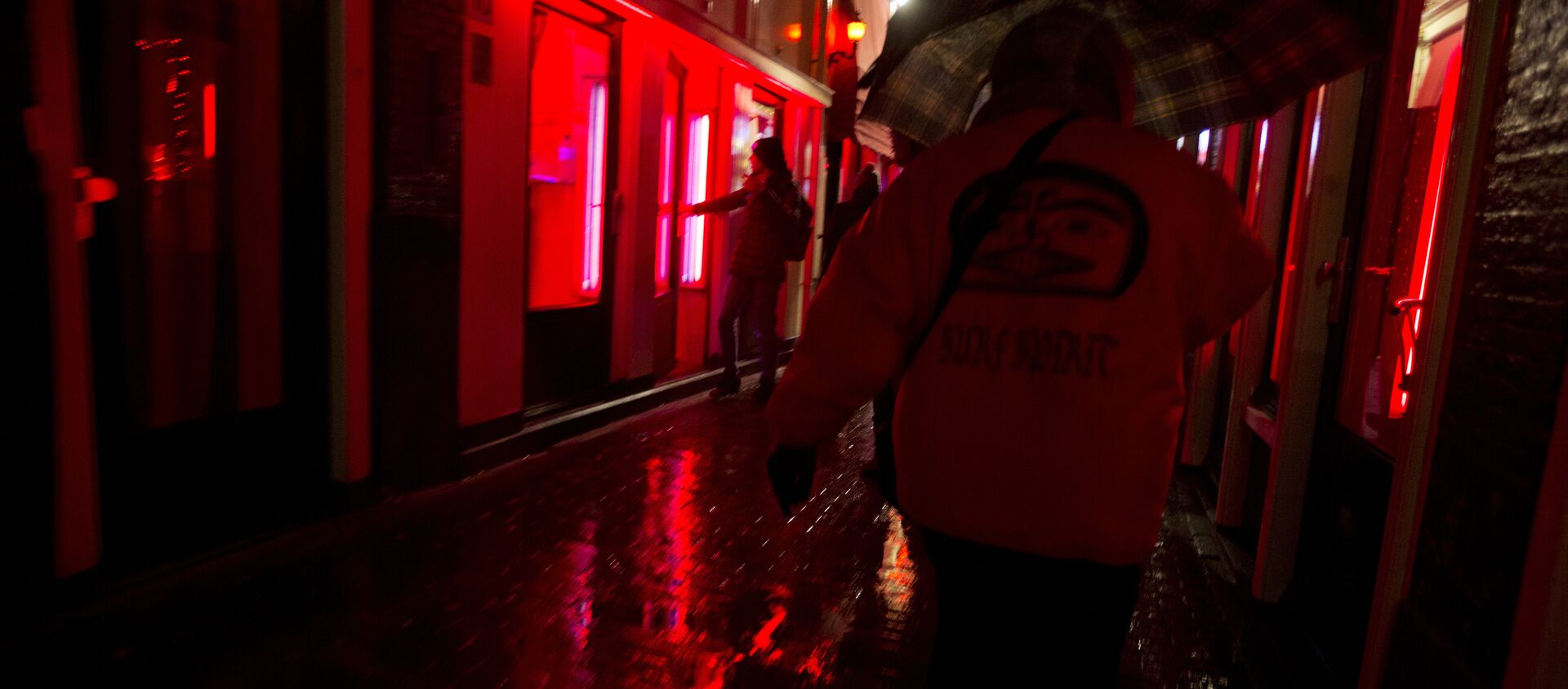 People walk through a narrow alley in the Red Light district in Amsterdam, Netherlands, Friday, Dec. 8, 2017. Every weekend, the heart of the historic port city, with its strip joints, seedy bars and scantily-clad prostitutes flaunting themselves behind plate glass windows, is overrun by foreign visitors over for stag and hen nights or to smoke marijuana in one of the city's many coffee shops. - Sputnik International, 1920