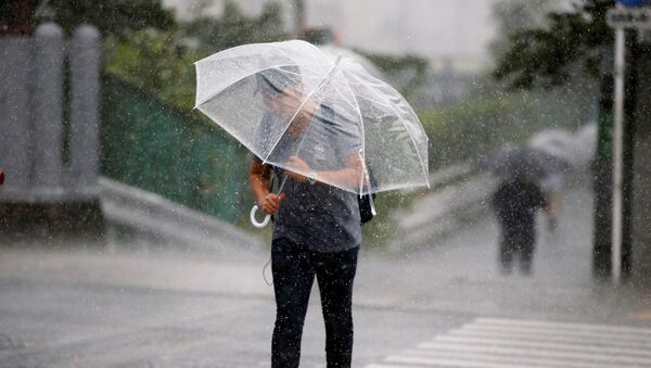 Passersby using umbrella struggles against a heavy rain and wind as Typhoon Jongdari approaches Japan's mainland in Tokyo, Japan July 28, 2018. - Sputnik International