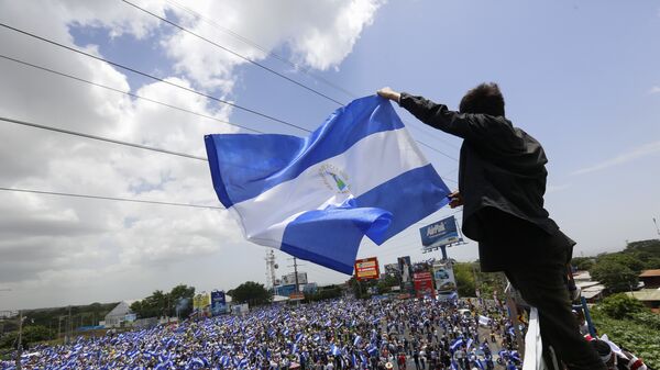 A man waves a Nicaraguan flag as people participate in a demonstration - Sputnik International