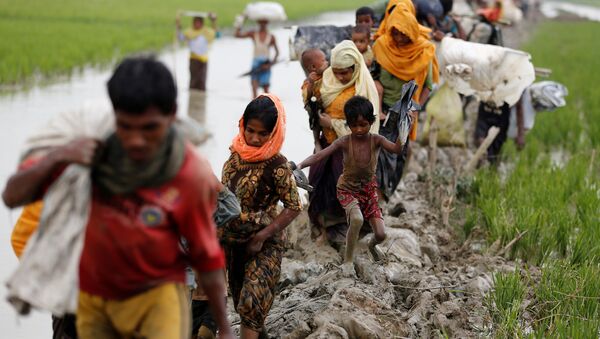 Rohingya refugees walk on the muddy path after crossing the Bangladesh-Myanmar border in Teknaf, Bangladesh, September 3, 2017. REUTERS/Mohammad Ponir Hossain - Sputnik International
