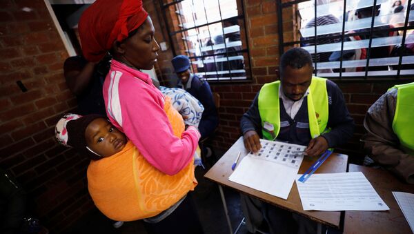 A Zimbabwean voter registers to cast her ballot in the country's general elections in Harare, Zimbabwe, July 30, 2018 - Sputnik International