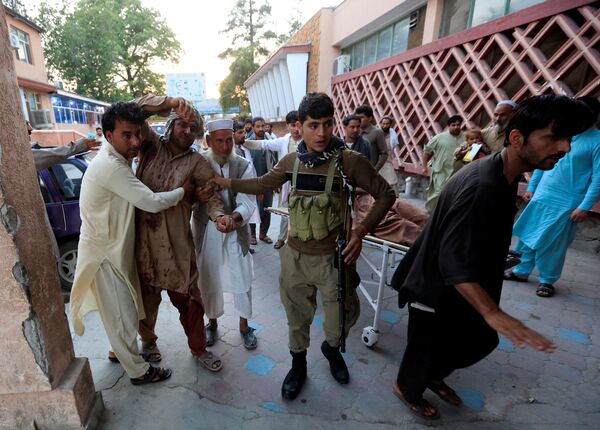 Men carry an injured man in a hospital after a suicide attack in Jalalabad, Afghanistan July 30, 2018 - Sputnik International