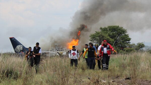 In this photo released by Red Cross Durango communications office, Red Cross workers and rescue workers carry an injured person on a stretcher, right, as airline workers, left, walk away from the site where an Aeromexico airliner crashed in a field near the airport in Durango, Mexico, Tuesday, July 31, 2018 - Sputnik International