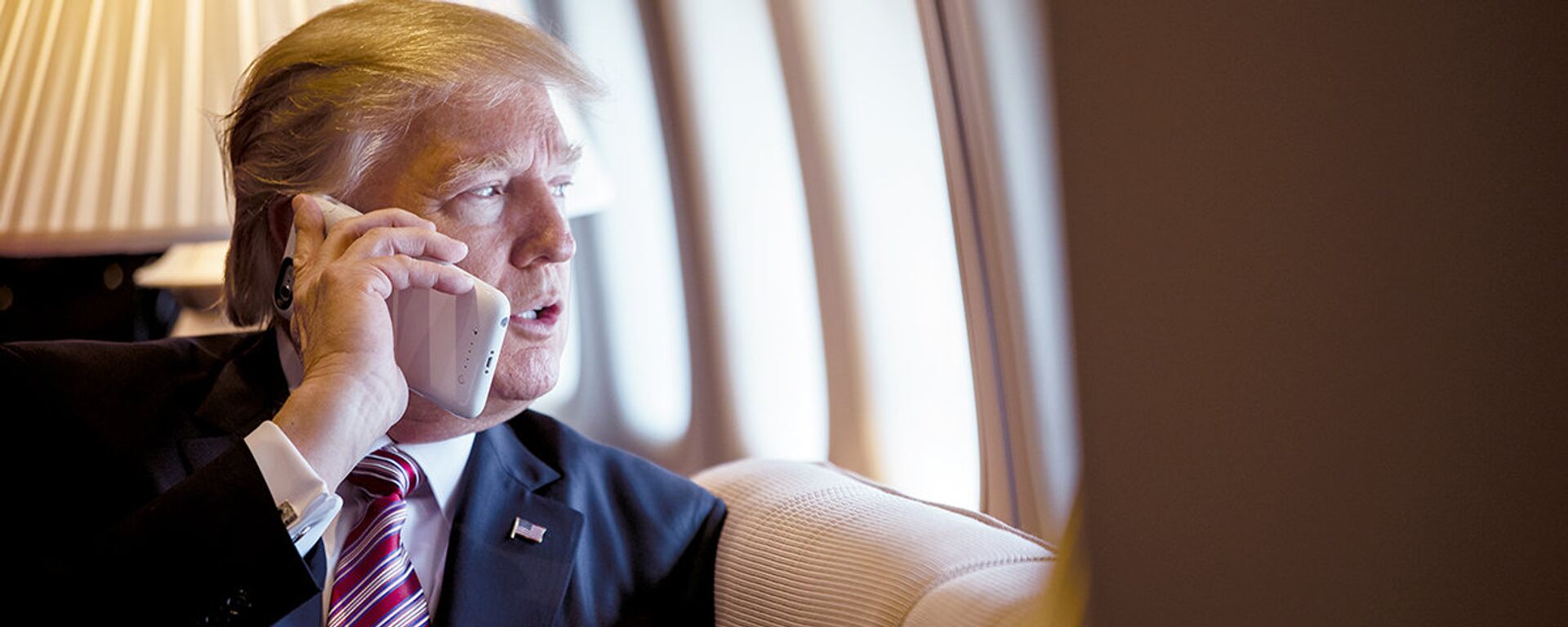 President Donald Trump talks on the phone aboard Air Force One during a flight to Philadelphia, Pennsylvania, to address a joint gathering of House and Senate Republicans, Thursday, January 26, 2017 (File photo). - Sputnik International, 1920, 25.03.2021