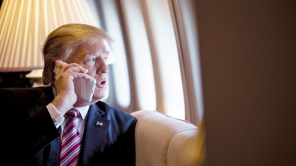 President Donald Trump talks on the phone aboard Air Force One during a flight to Philadelphia, Pennsylvania, to address a joint gathering of House and Senate Republicans, 26 January 2017 (File photo). - Sputnik International